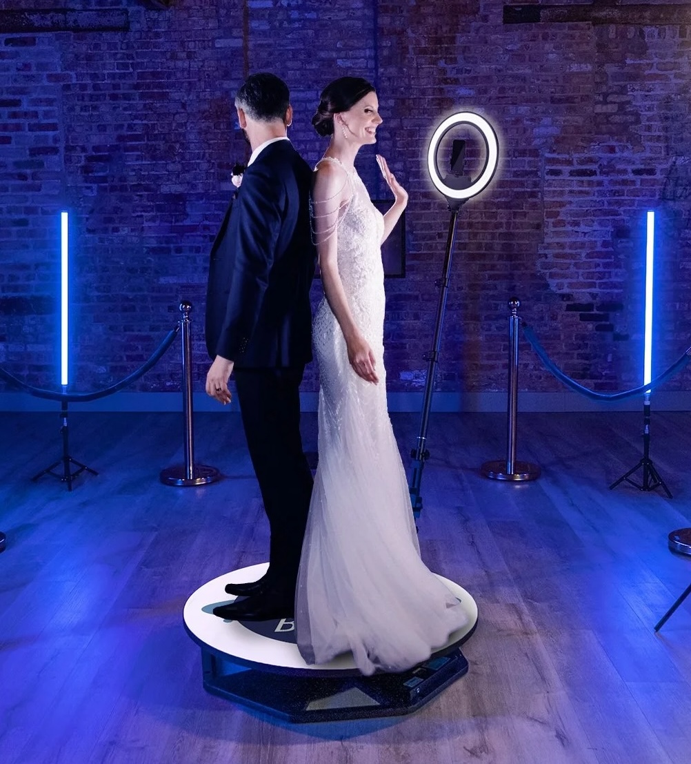 A bride and groom on the 360 photo booth on their wedding day.